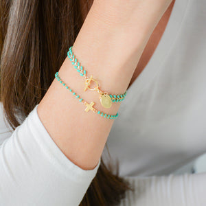 vine gold bracelet with turquoise enamel and disc charm with cross