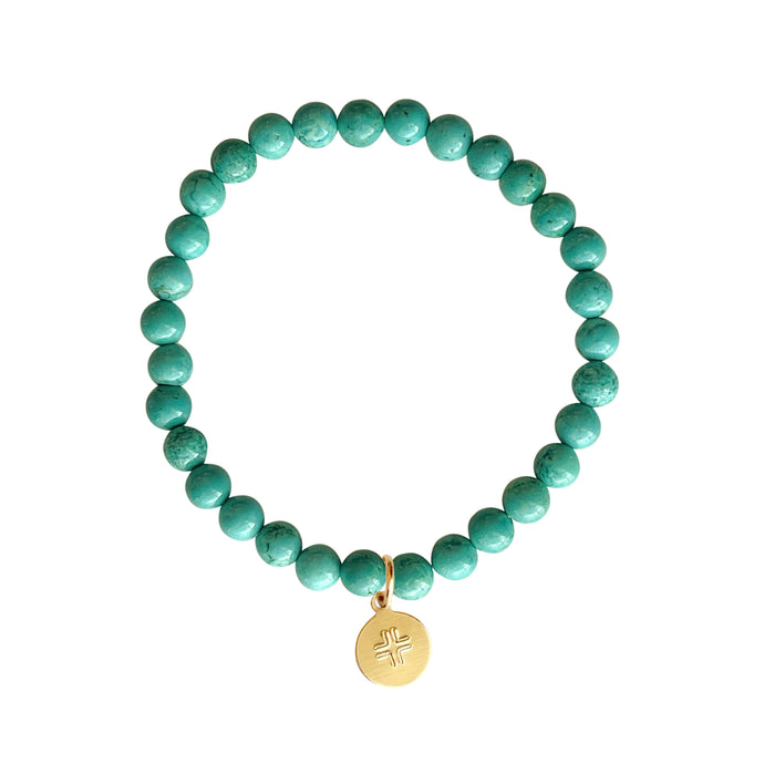 Turquoise Howlite stone stretch bracelet with gold disc with cross charm.