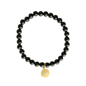 Black Onyx stone stretch bracelet with gold disc charm with cross.